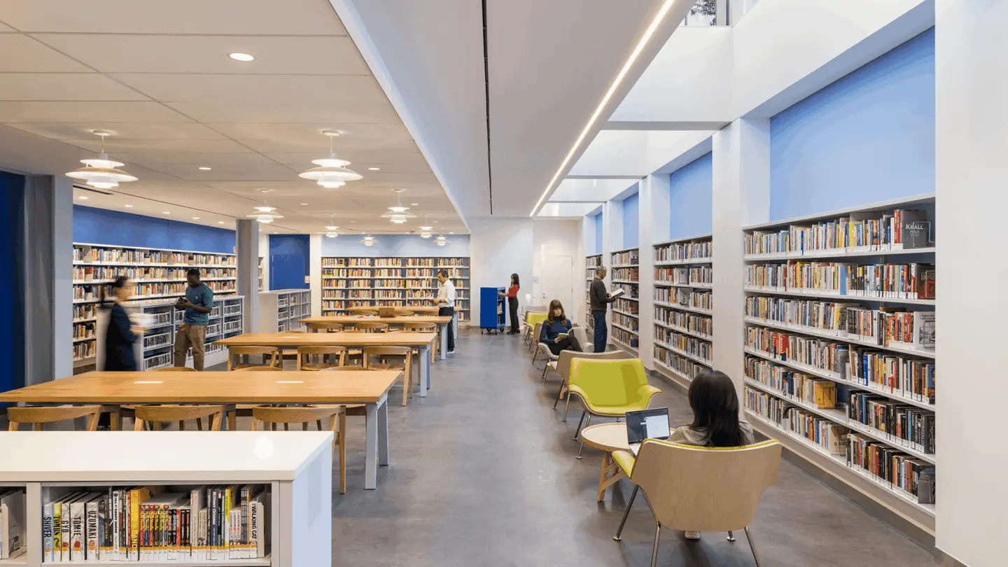 Multiple people standing and sitting in the Brooklyn public library