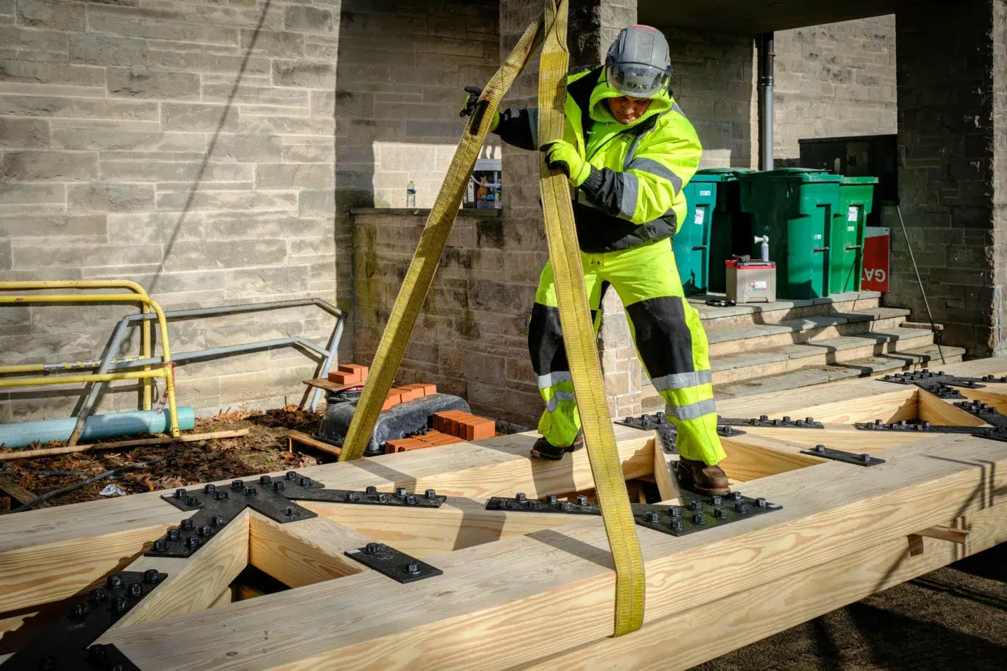 Man standing on large lumber trusses