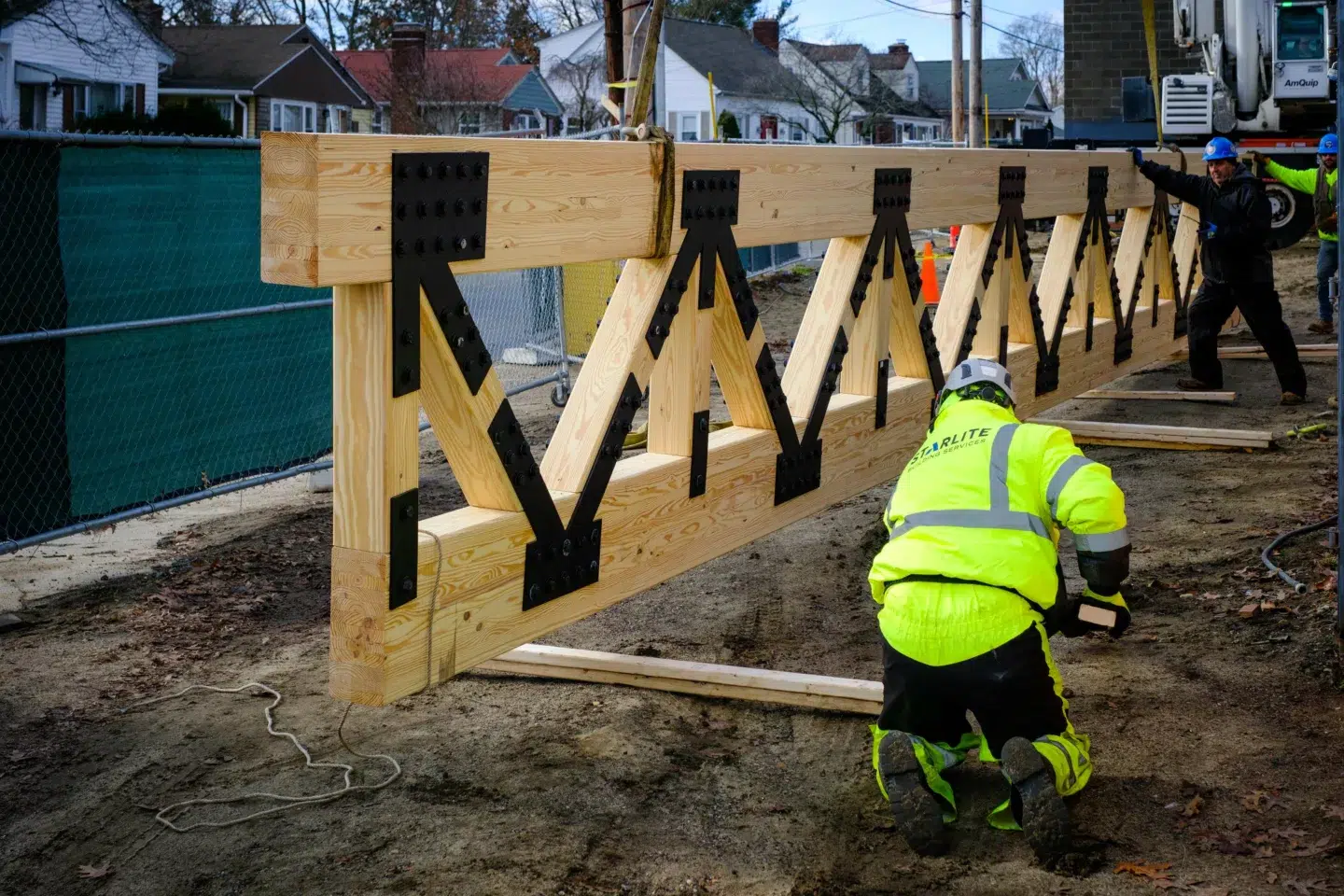 Man working on large lumber trusses