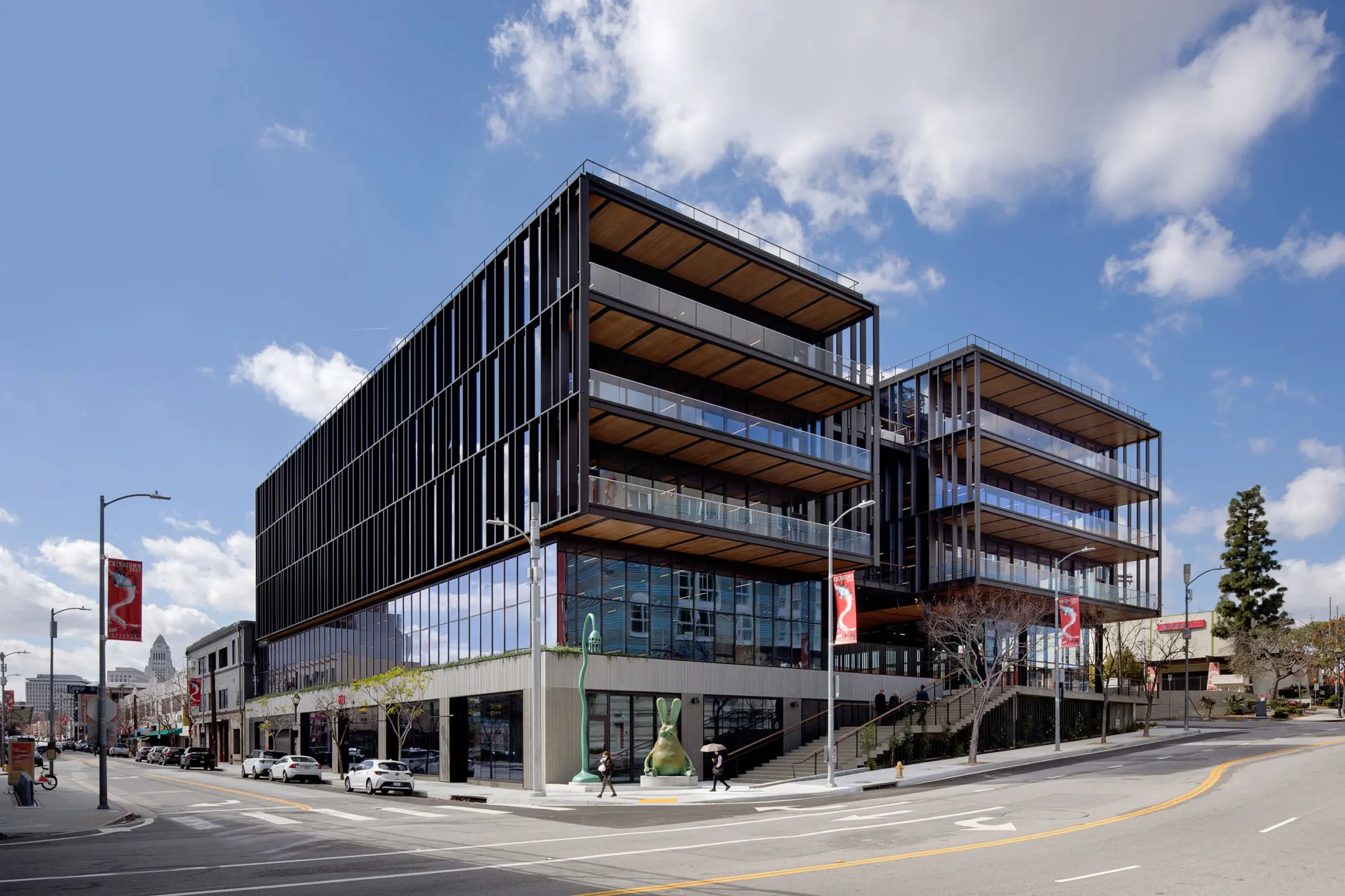 Five story glass building with concrete footing and blue skies