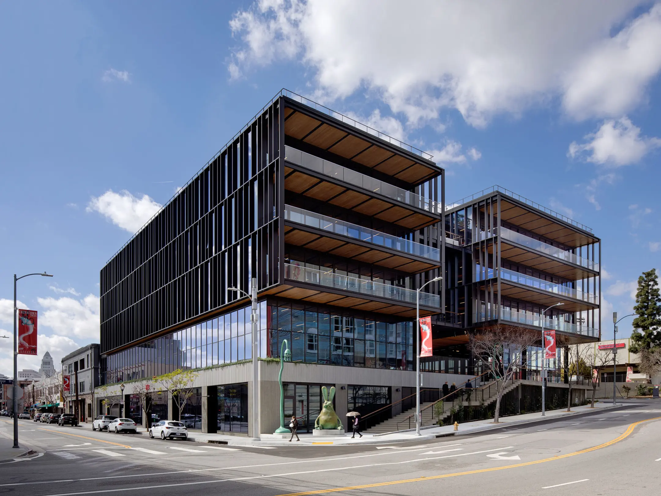Five story glass building with concrete footing and blue skies