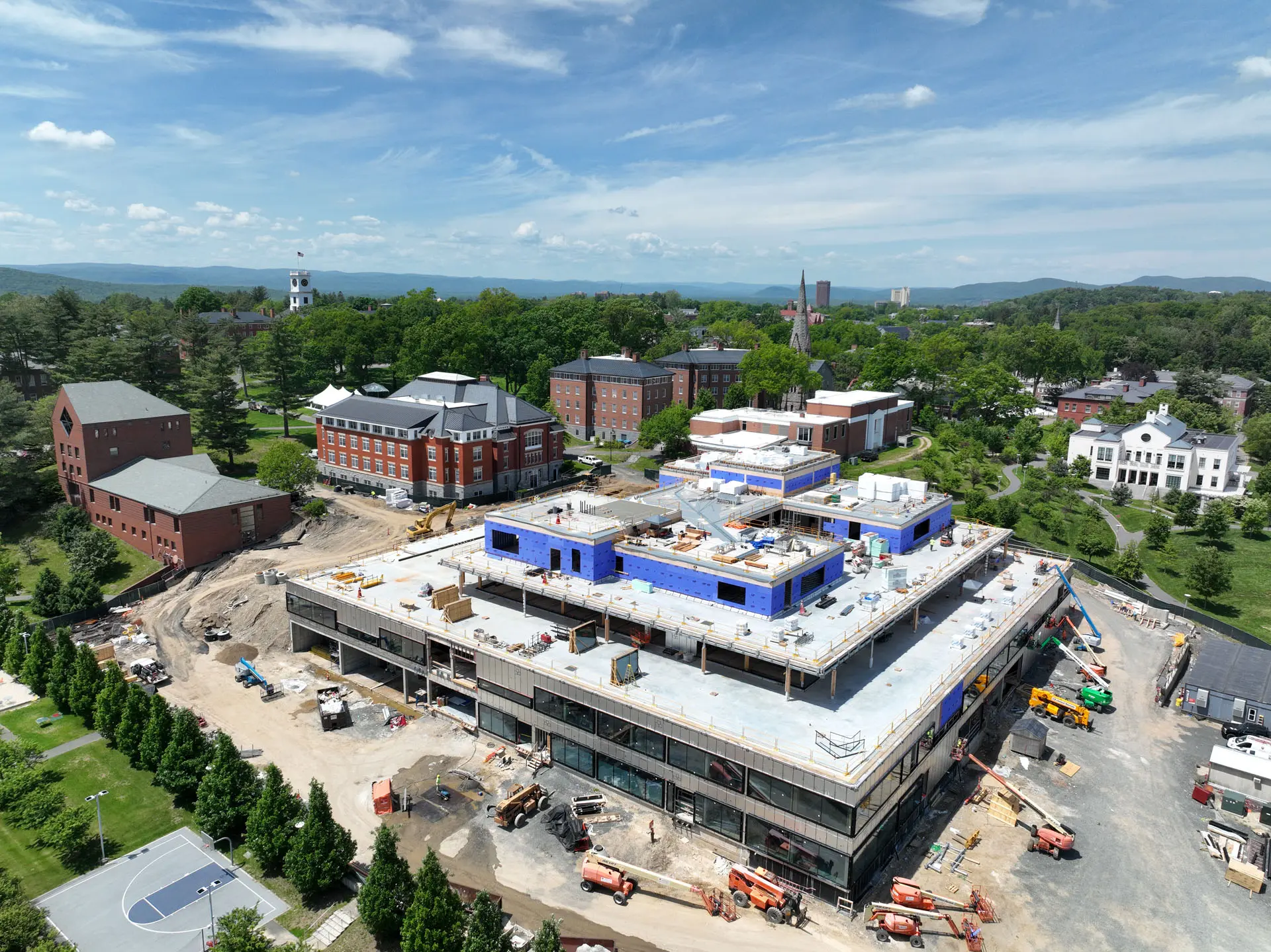 drone capture of cross laminated timber project at Amherst College with cranes at ground level and sheetrock on top floor
