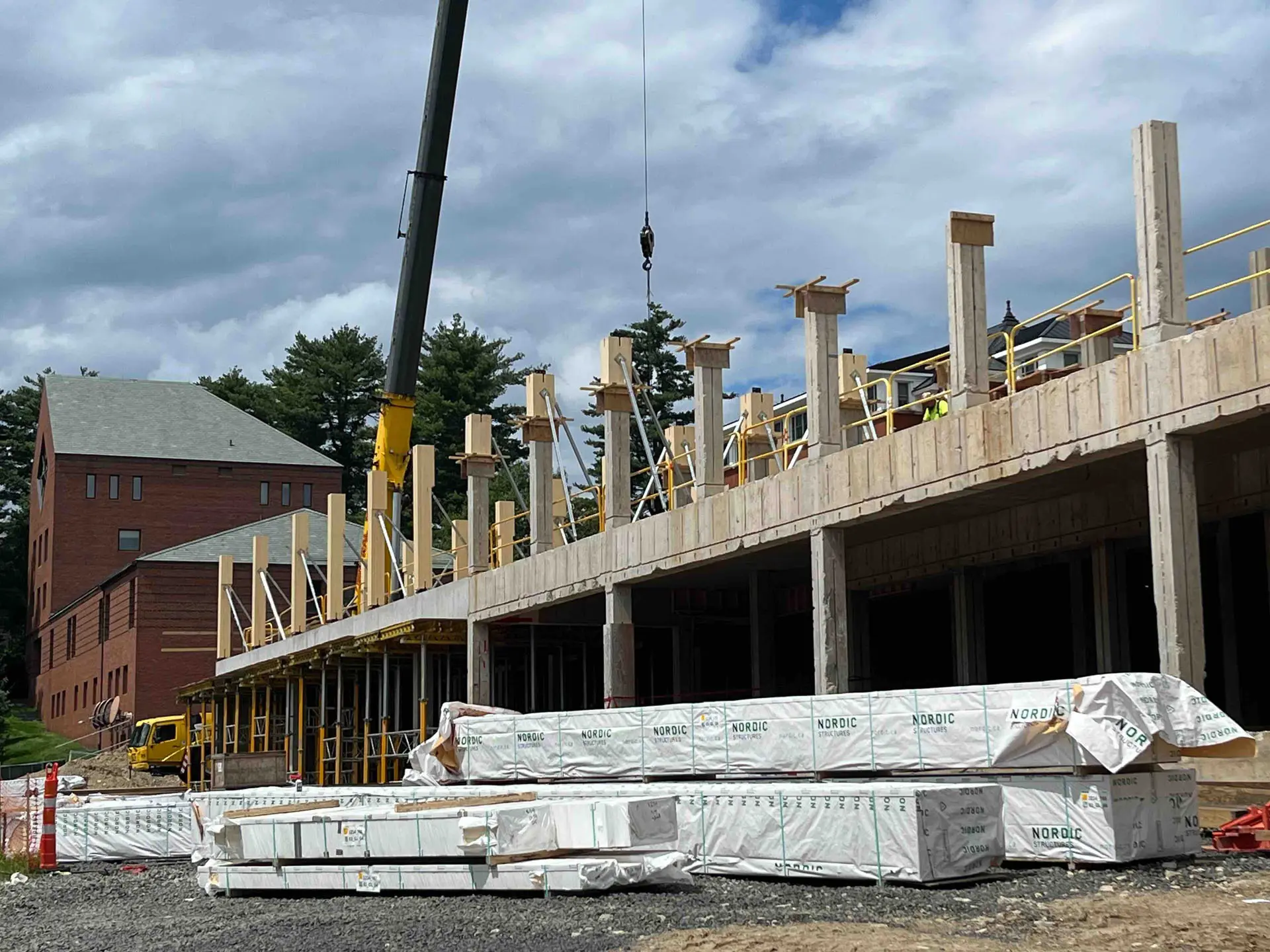 View from ground of concrete foundation and placement of cross timber vertical beams