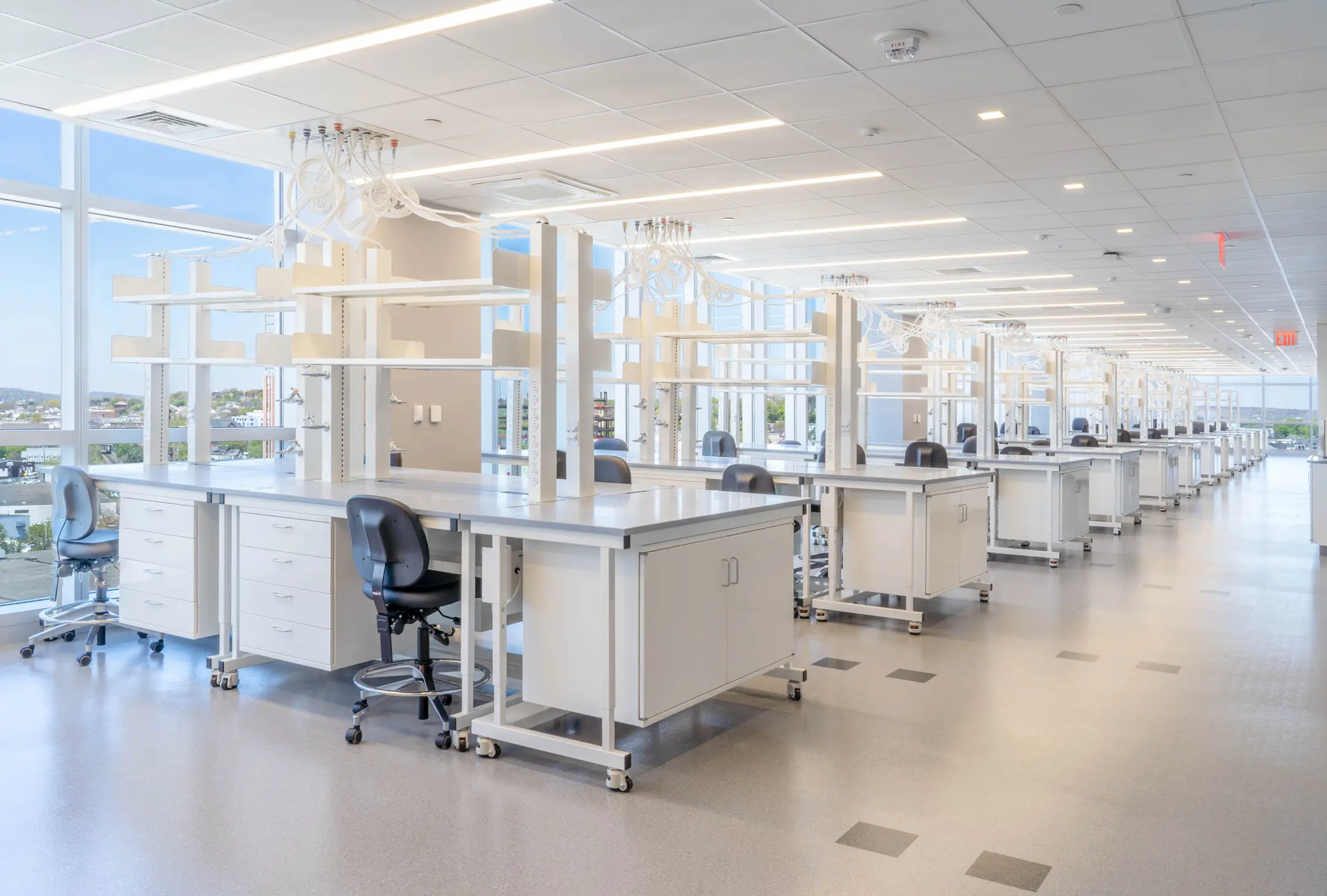 Lab desks lined along glass walls in long room