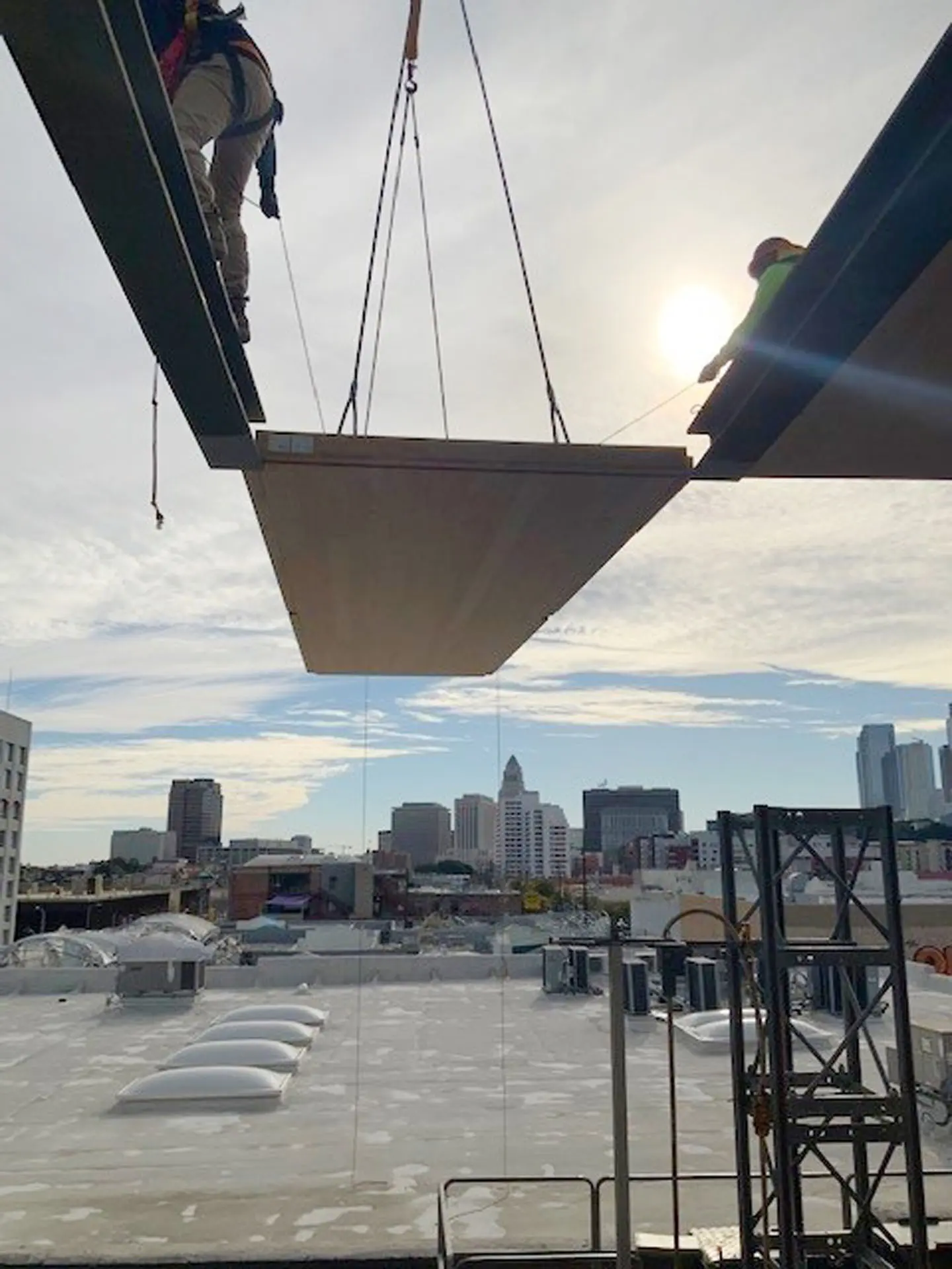 Two workers installing wooden flooring into steel beams at the 843 North Spring Street building