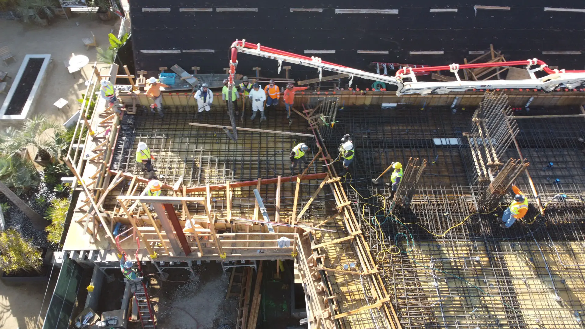 Overhead view of workers on rebar pouring concrete from pump truck