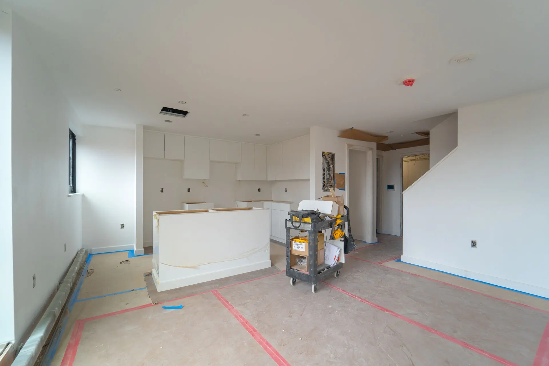 Interior of apartment with white millwork in progress and workman's trolley