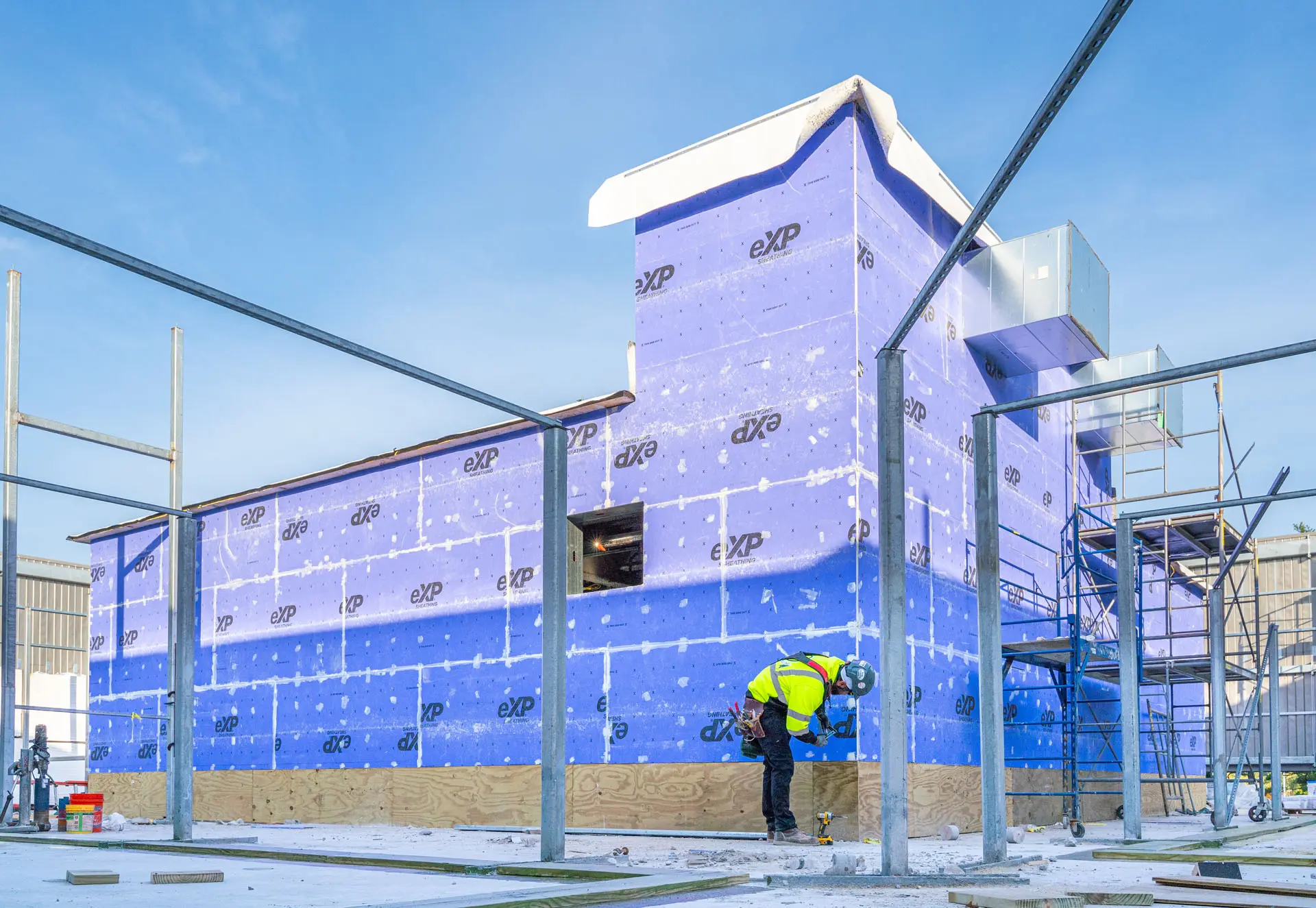 Man in safety gear working on sheeting the Riverside Lab