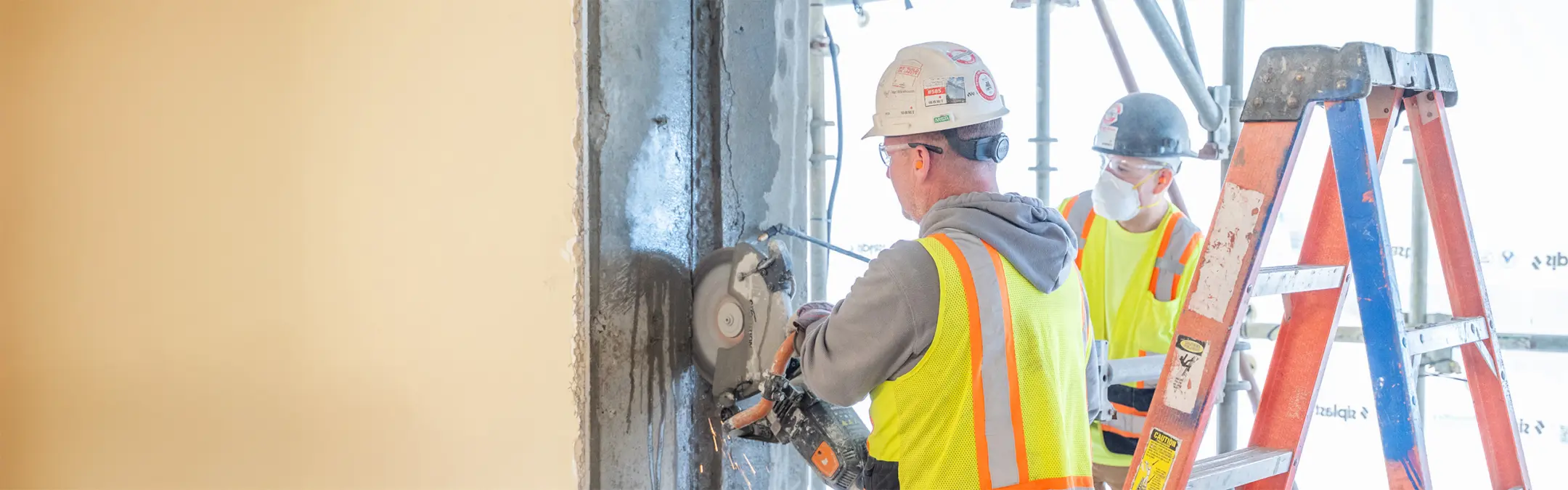 Man using saw on concrete wall