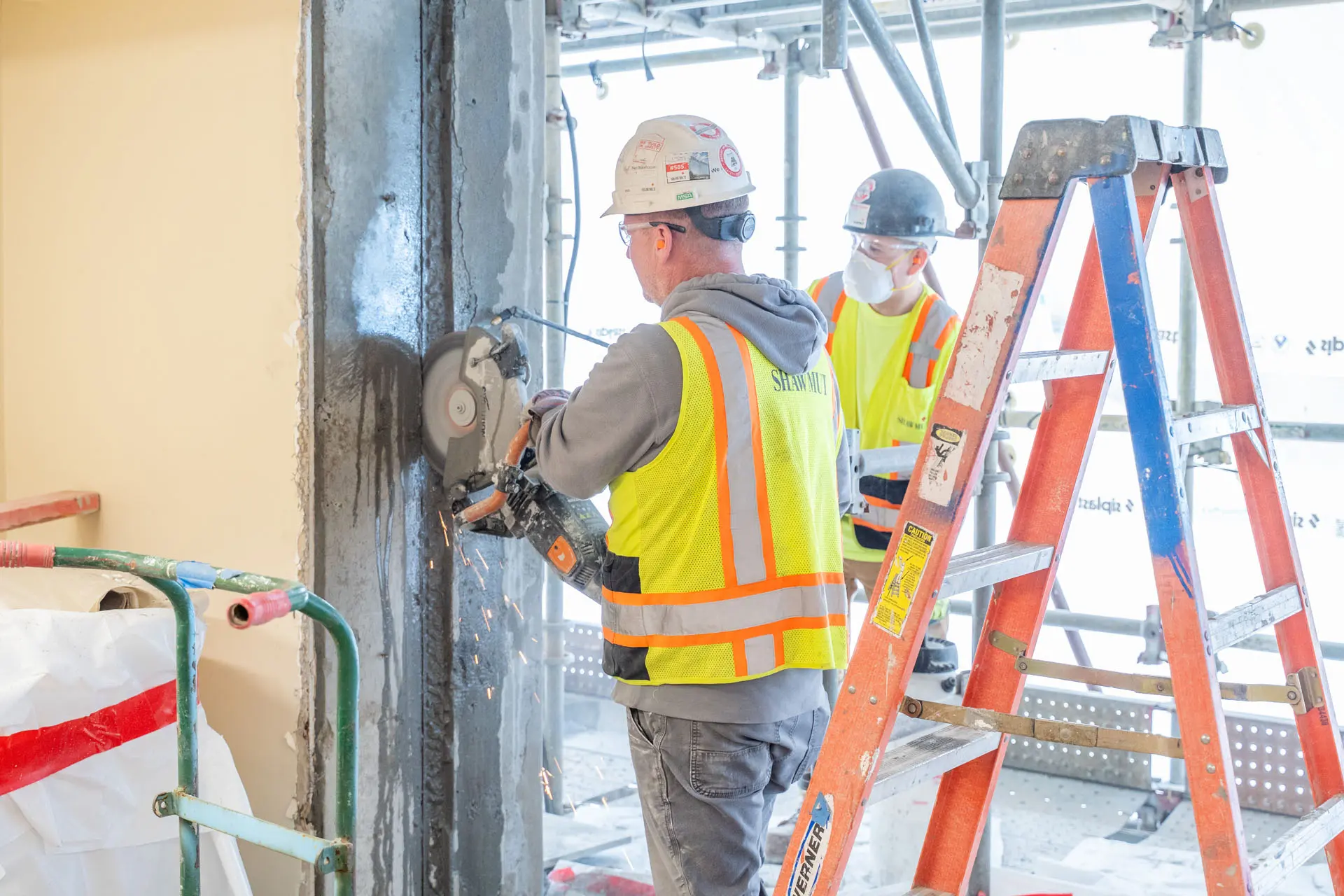 Worker using a power saw on a wall