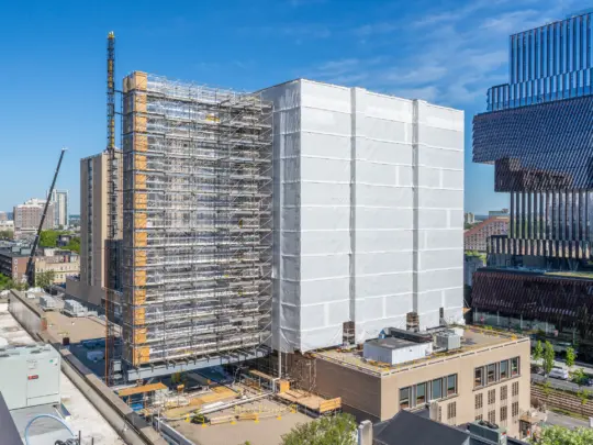 Multistory skyscraper covered in large white tarp