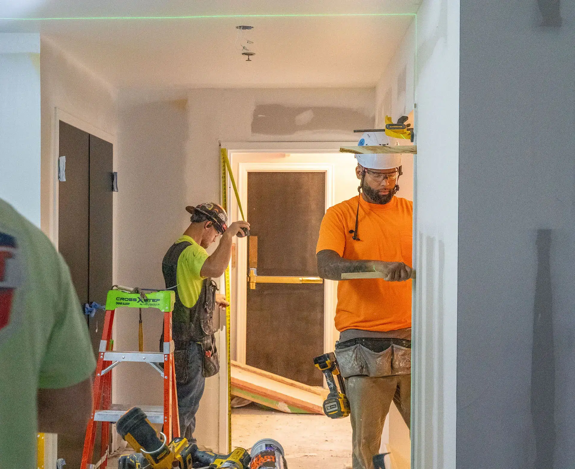 Men working on doorframes inside house