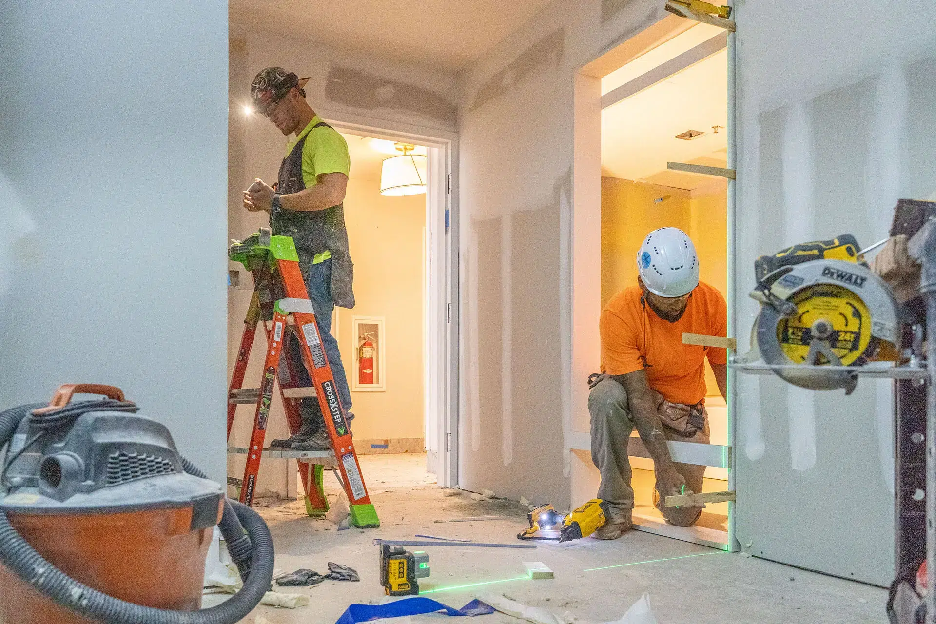 Men working on doorframes inside house