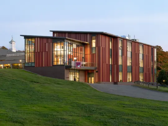 Red three story building on a hill at Pomfret Academy