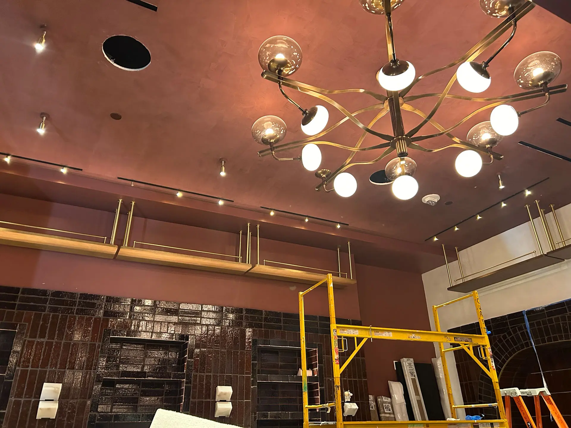 View of chandelier with milk and clear glass bulbs and a burnt sienna ceiling