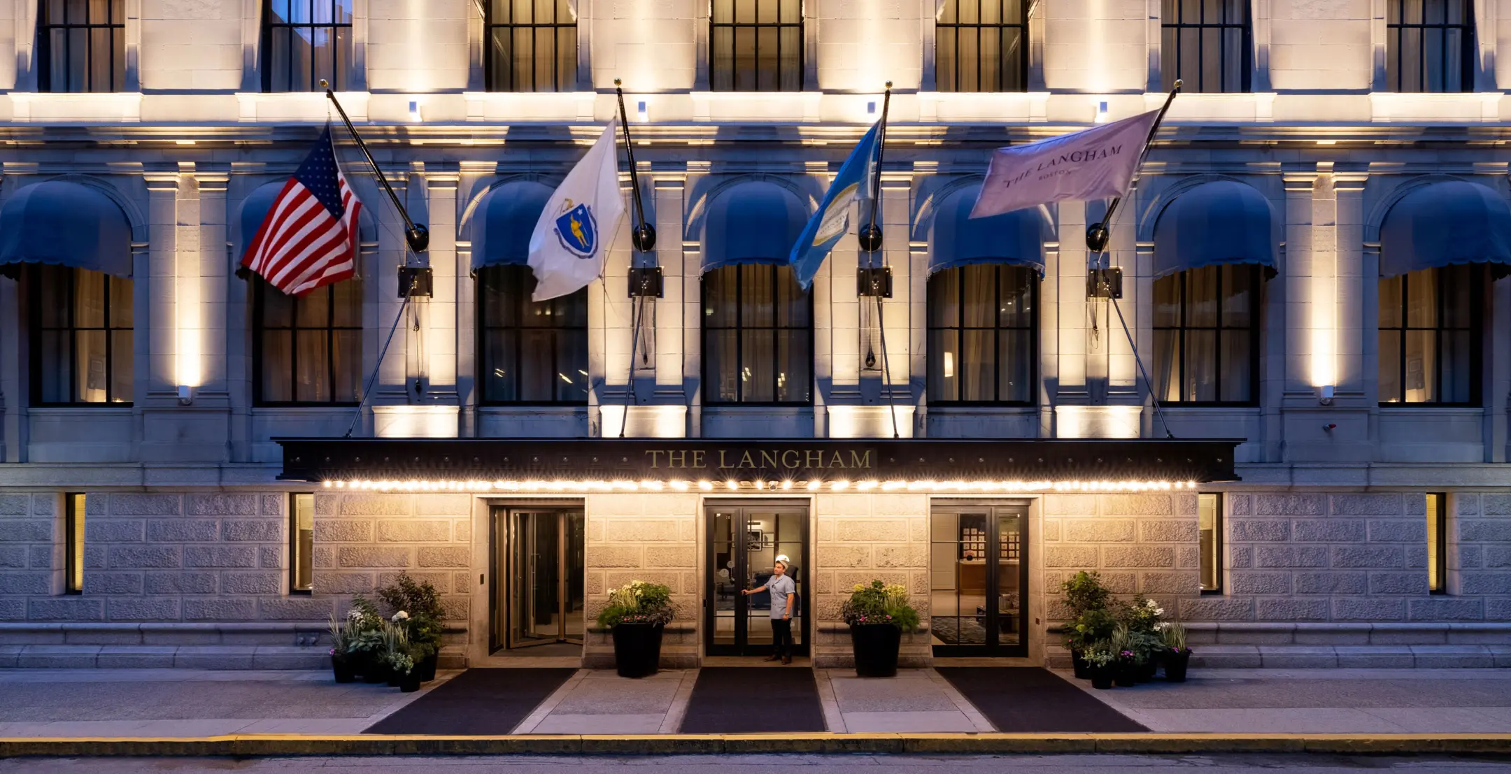 Exterior of hotel with bellhop holding door