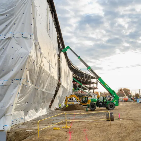 Boom fork lift lifting materials multiple stories up in building