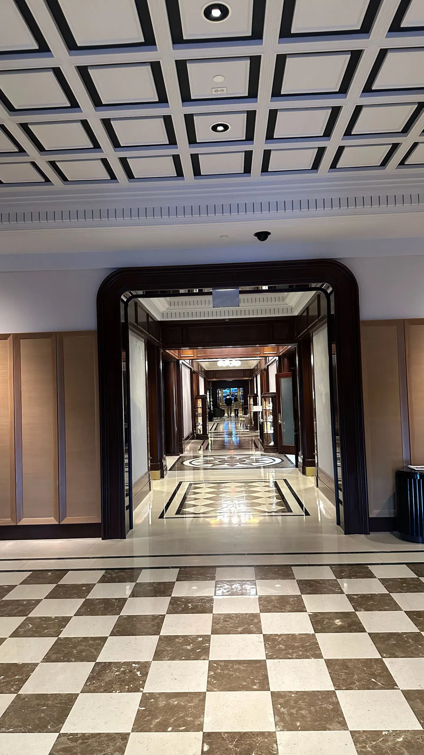 hallway with checkered marble floor and coffered ceiling
