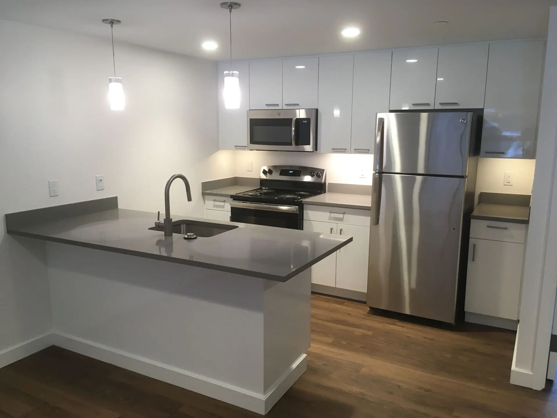 Interior of kitchen with sink, refrigerator, stove, and microwave