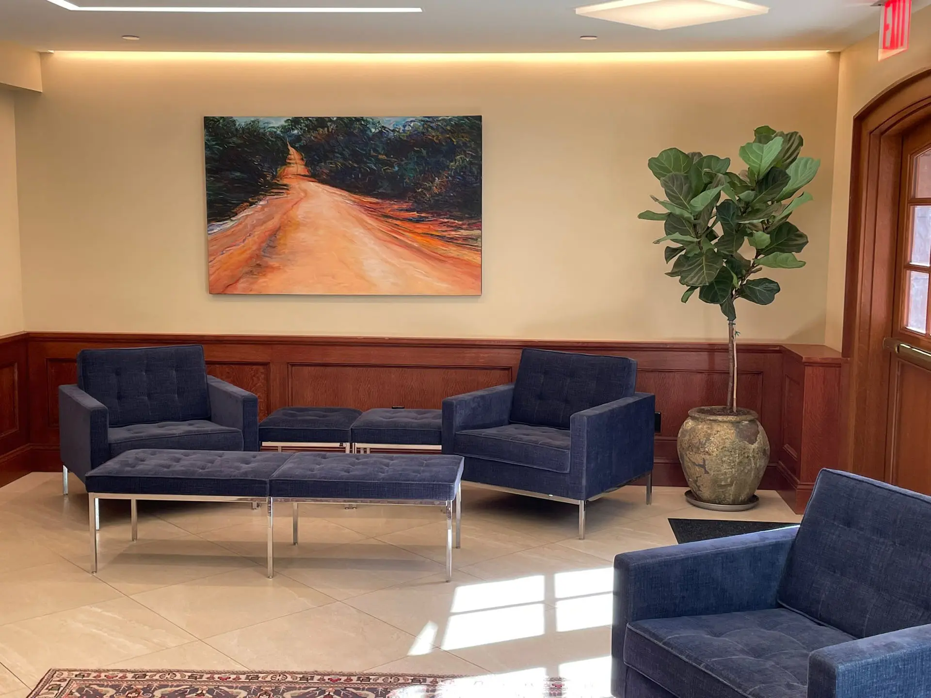 Entryway into Church of the Epiphany with seating area, fiddle leaf fig, and painting on wall