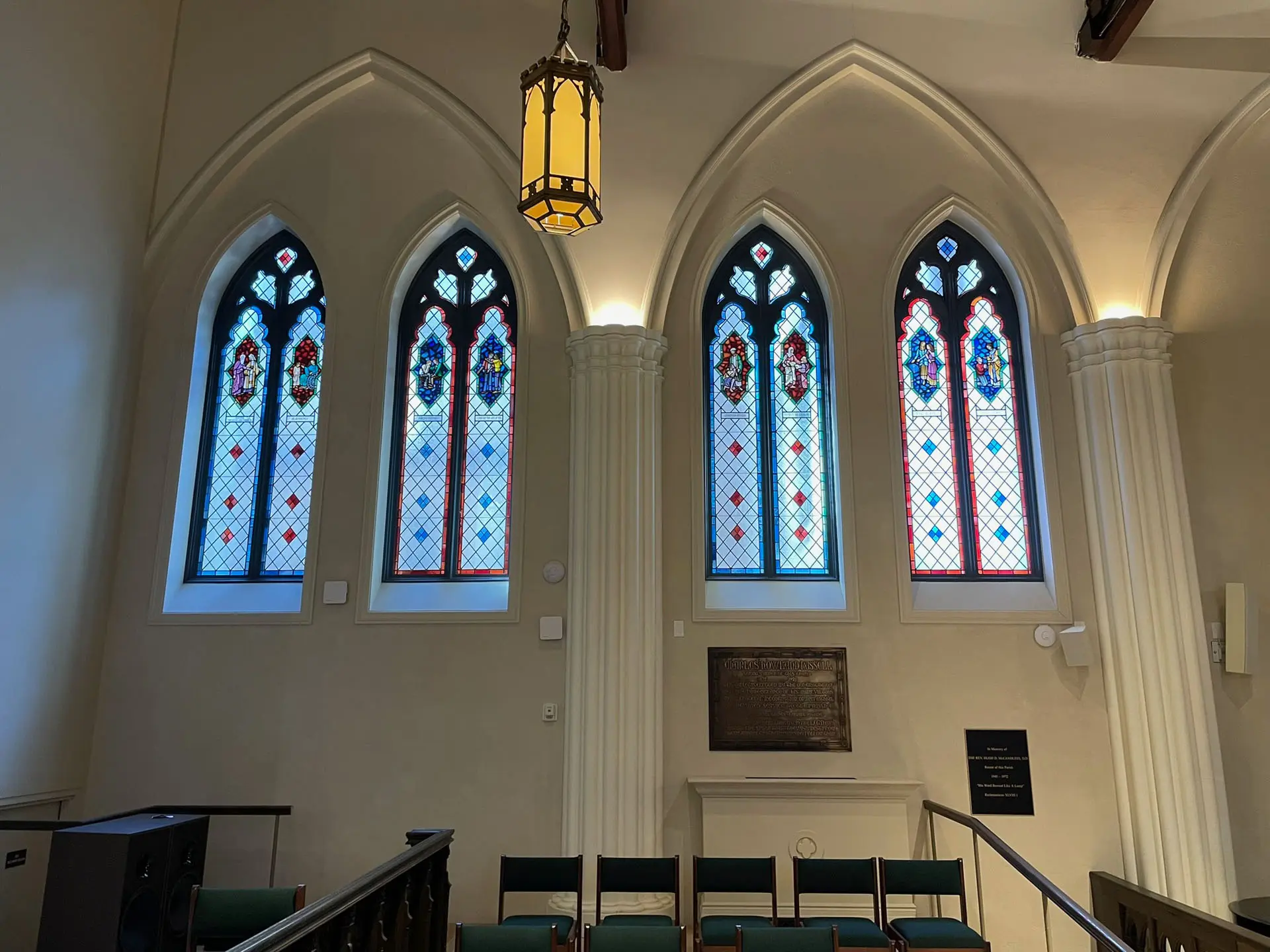 Arched stained glass windows with wooden trim