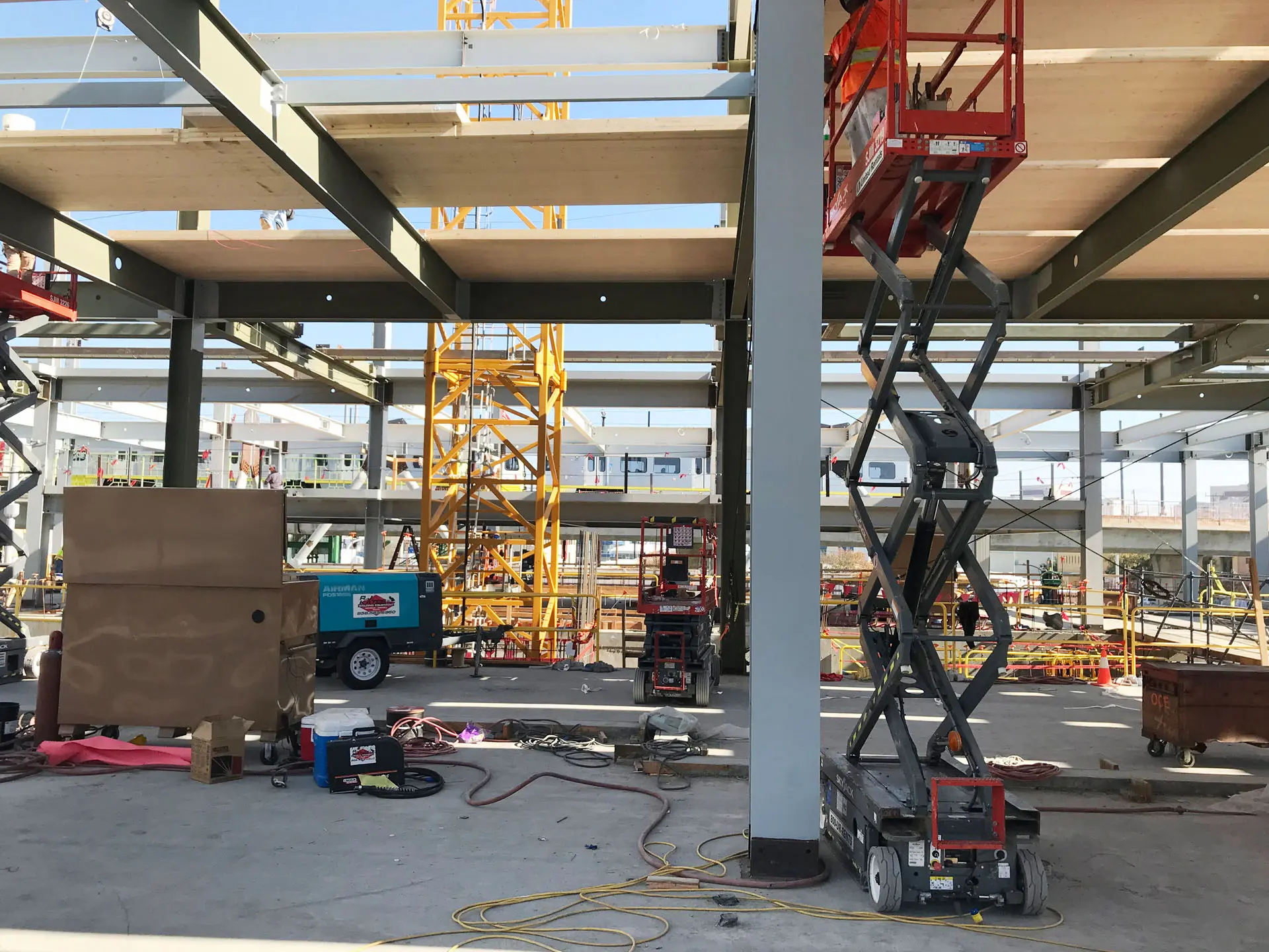 Three scissor lifts inside the concrete, steel, and glass 843 North Spring Street Building
