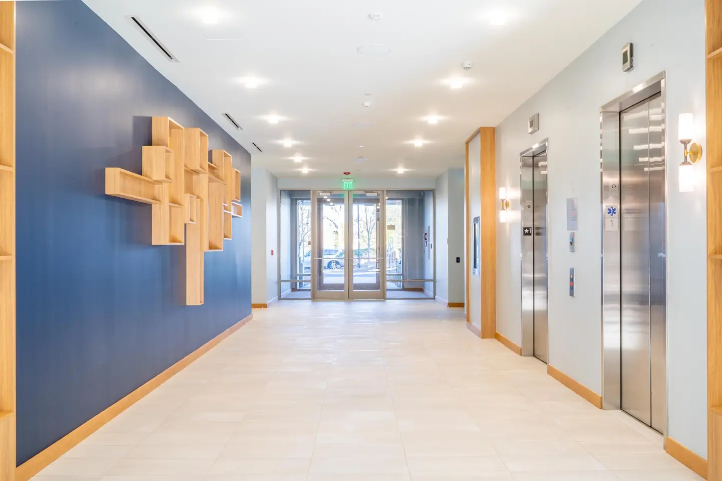 Entryway with elevators and large wooden sculpture on wall