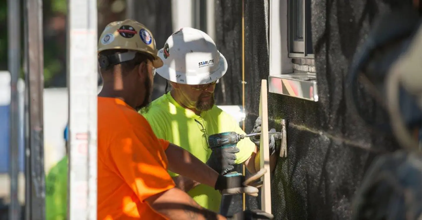 Men drilling into wall