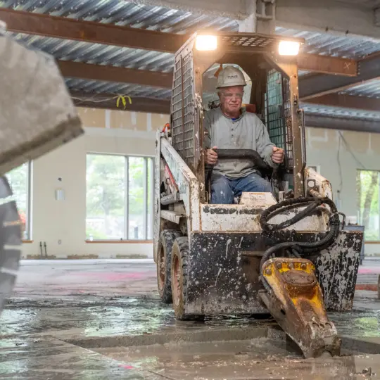 Skid steer jackhammer destroying concrete floor