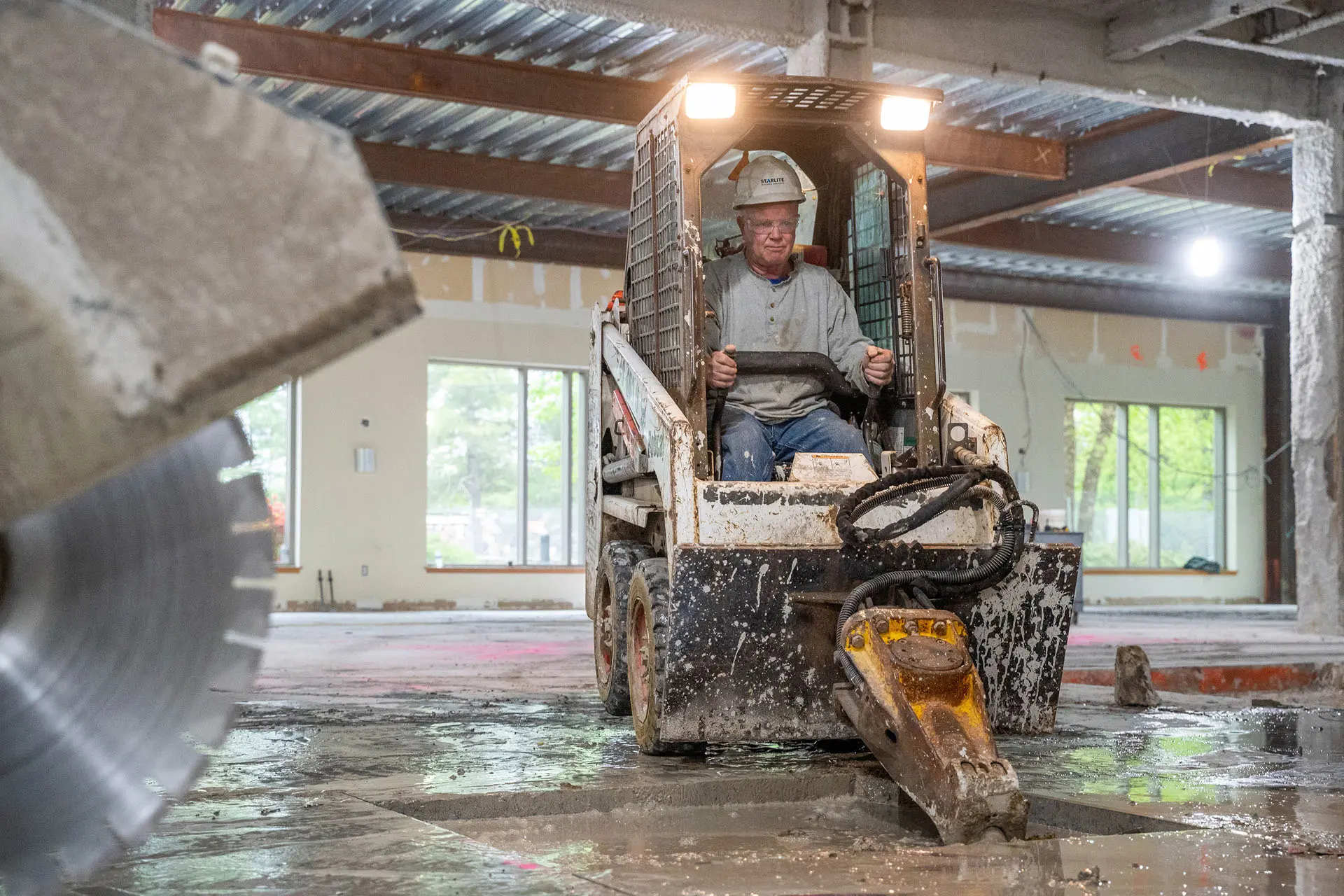 Skid steer jackhammer destroying concrete floor